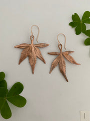 real cannabis leaf earrings electroplated with recycled copper ans 14 karat gold by simple wealth art made in usa